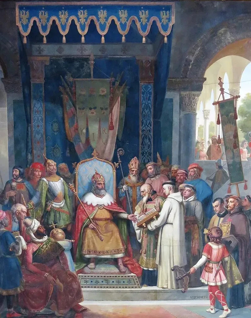 A 19th-century oil: Charlemagne, crowned and robed in red and gold, enthroned beneath a blue canopy of eagle banners, extends his hand toward a tonsured monk presenting an illuminated manuscript; a mitred bishop, courtiers and a page look on in a colonnaded hall.