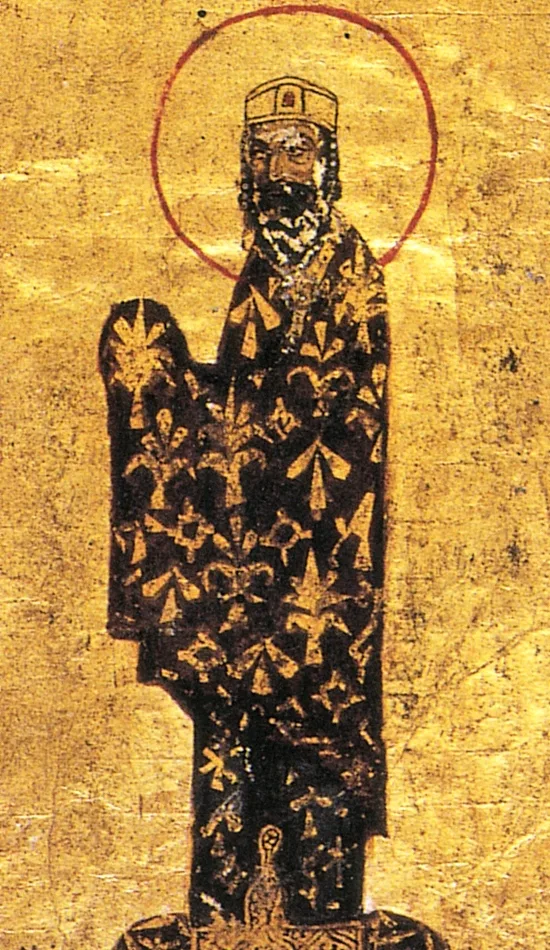 A Byzantine manuscript portrait on a solid gold ground: a standing, haloed, crowned emperor in a dark jeweled robe patterned with gold fleurs-de-lis, a small kneeling figure at his feet.
