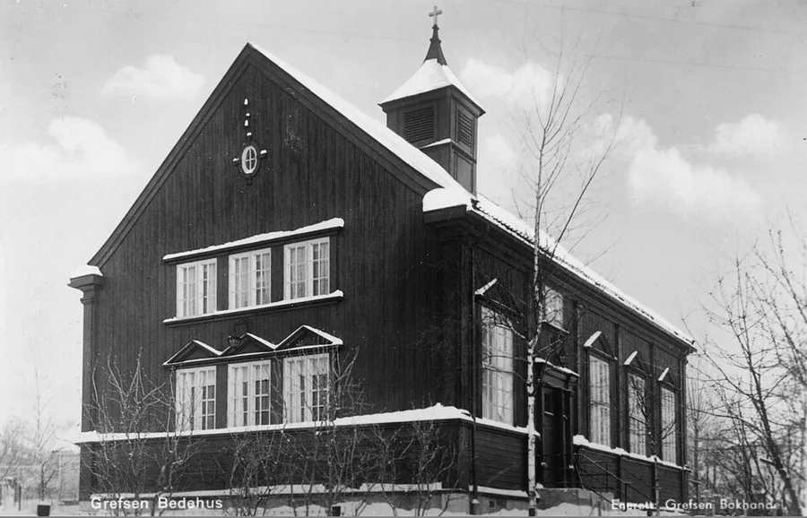 Black-and-white postcard photograph, captioned 'Grefsen Bedehus,' of a snow-covered gable-roofed timber prayer house with a small cross-topped bell tower, tall arched windows, and bare winter trees in front.