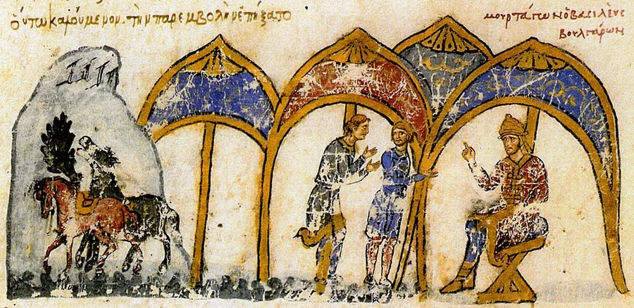 Miniature from the Madrid Skylitzes: beneath gold pointed arches, two envoys confer before the enthroned Bulgar ruler Omurtag, who raises a finger in instruction; at left a horseman rides past a grey rocky citadel, with red Greek captions written across the parchment.