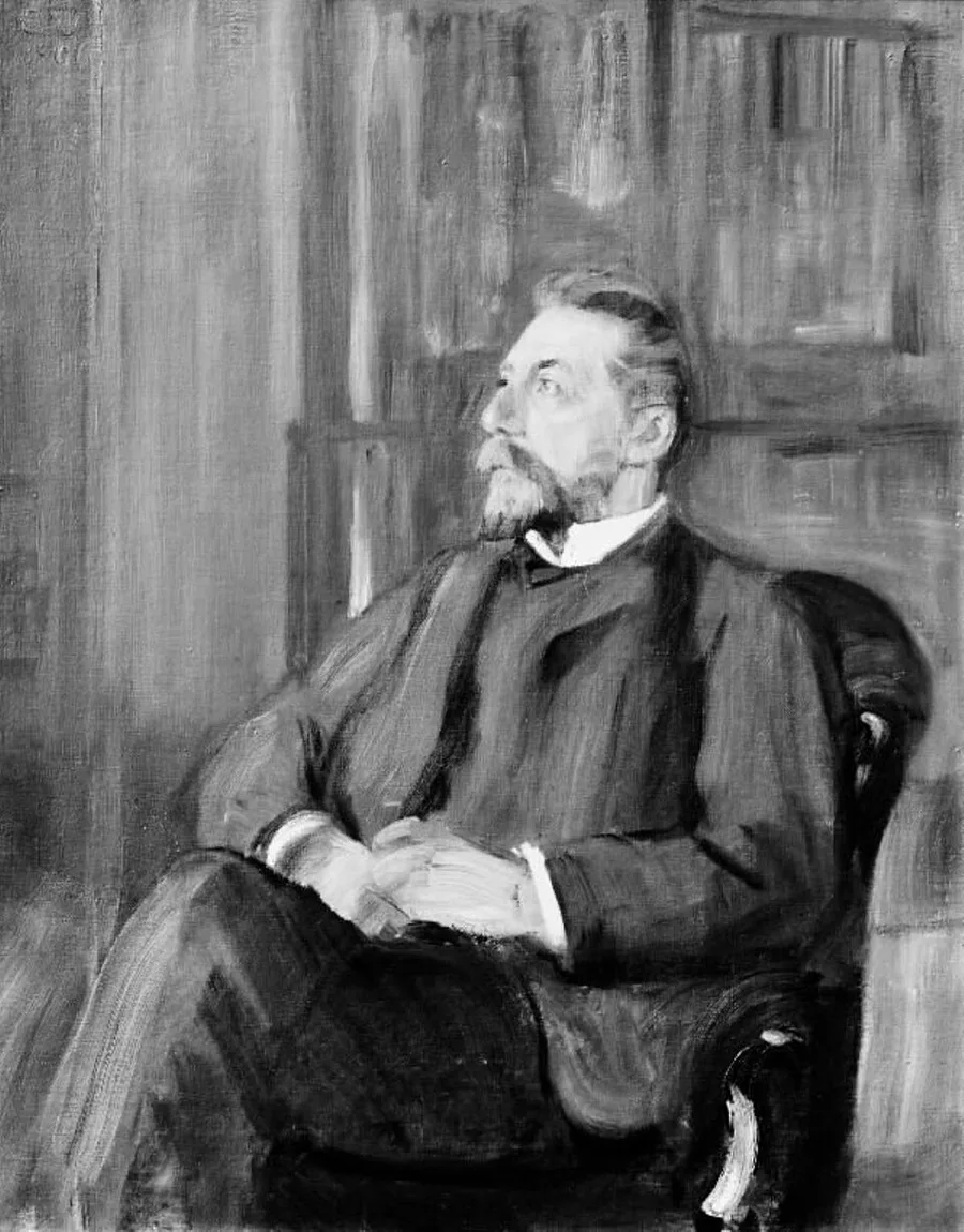 Grayscale digitization of a painted seated portrait of a bearded man in a dark suit and bow tie, seen in three-quarter profile with hands clasped in his lap, in a book-lined room — Erik Werenskiold's 1906 portrait of Christian Michelsen.