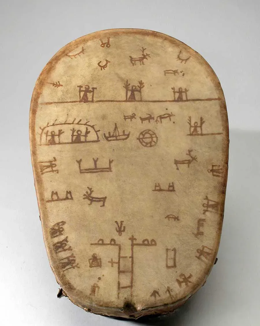 A Sámi bowl drum (goavddis) from Lule Lappmark seen from above — reindeer hide stretched over a carved birch bowl, rows of red-brown cosmological figures painted across the membrane.