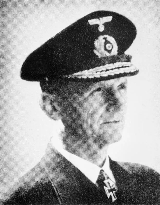 Black-and-white head-and-shoulders portrait of Karl Dönitz in German naval uniform, wearing a peaked cap with an eagle badge and an Iron Cross at his collar.