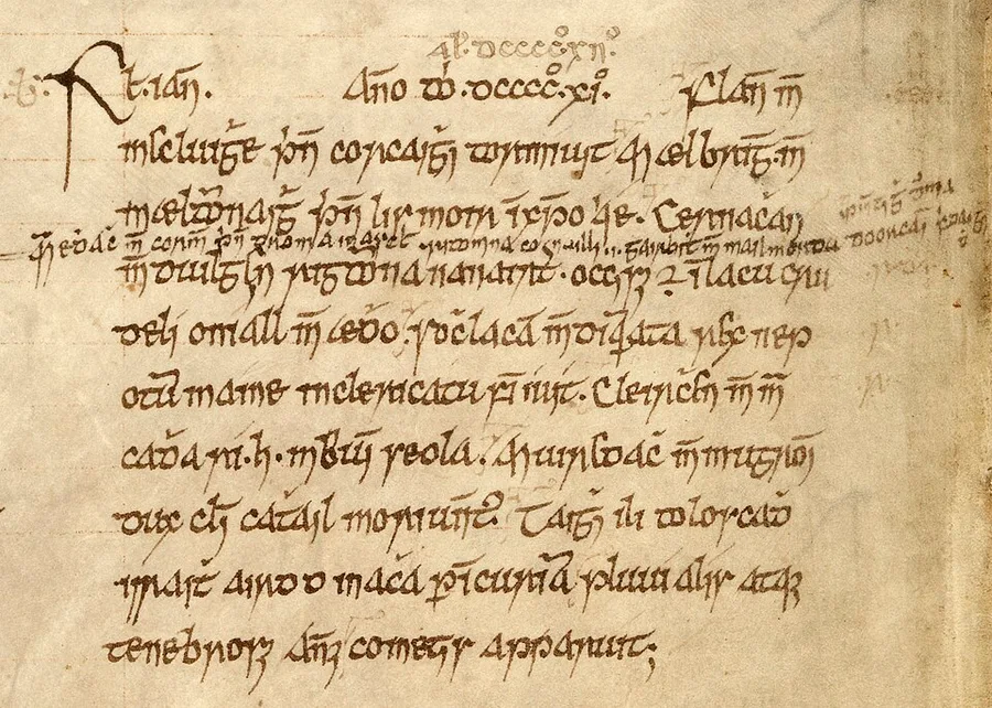 Close-up of an Annals of Ulster entry: a dozen lines of medieval Irish minuscule in brown ink on tan vellum, opening with the year heading Anno Domini dcccc.xi — a later hand adds the corrected year above — with smaller interlinear and marginal additions.