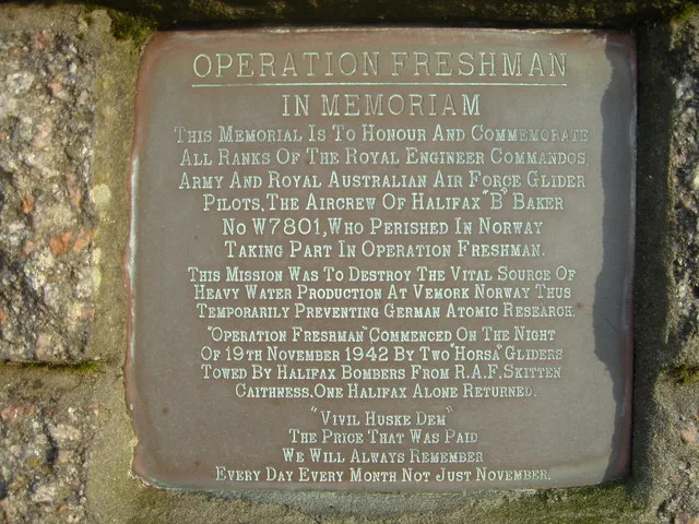 Photograph of a bronze memorial plaque titled "Operation Freshman, In Memoriam," honoring the Royal Engineer commandos and RAF aircrew who died in the November 1942 glider raid, mounted on a stone plinth at the former Skitten airfield.