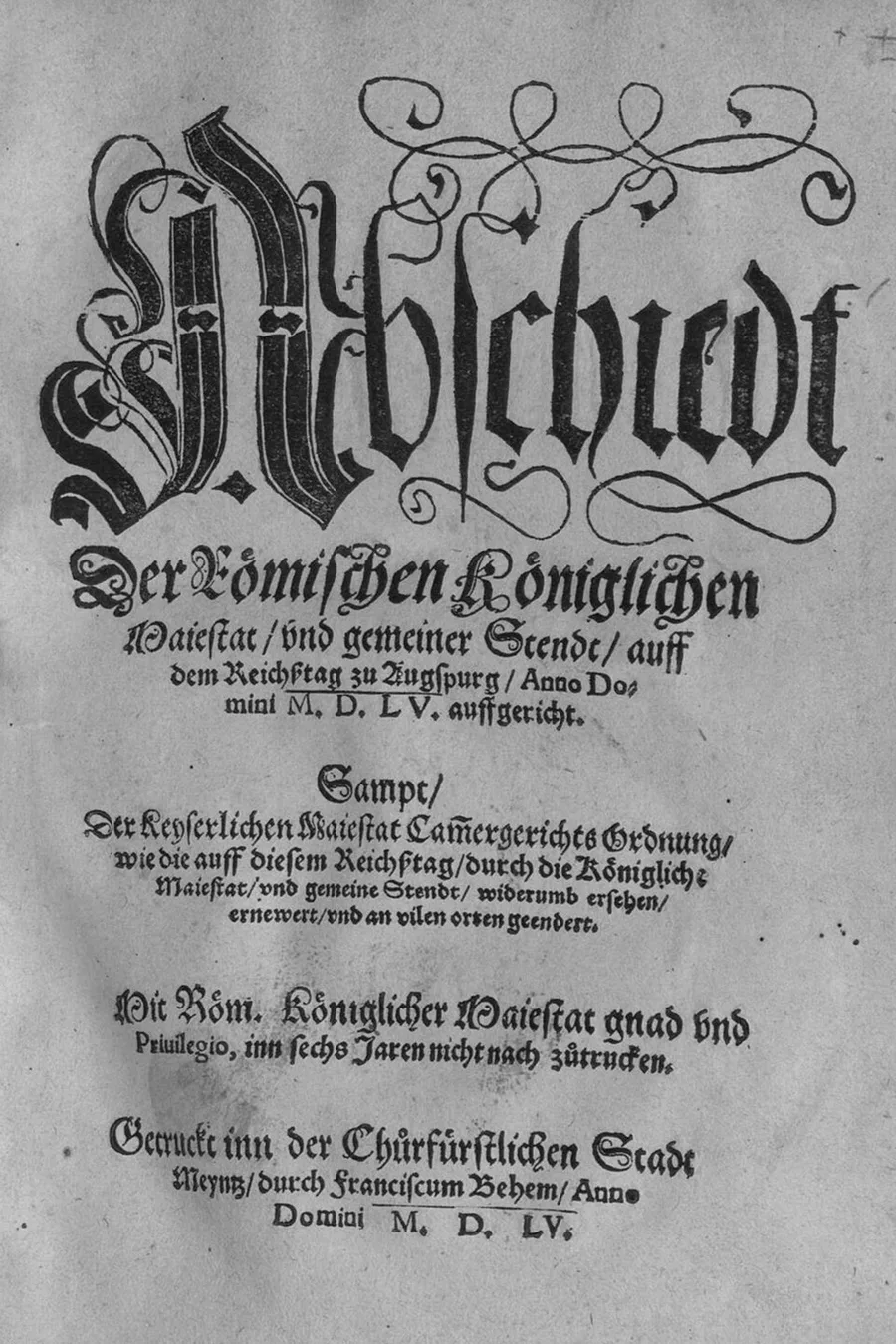 The black-letter German title page of the 1555 printed Augsburg Imperial and Religious Peace, headed by an ornate flourished "Abschiedt" initial, naming the Diet of Augsburg of 1555 and the Mainz printer Franciscus Behem.