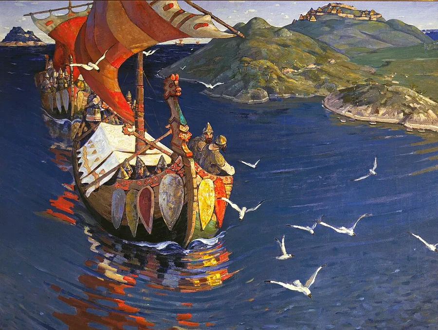 Roerich's Guests from Overseas (1901): a dragon-prowed longship with red-and-white striped sails and a row of painted shields along its gunwale, helmeted warriors aboard, a second ship following; white gulls skim deep-blue water and a hilltop wooden town crowns the green shore.