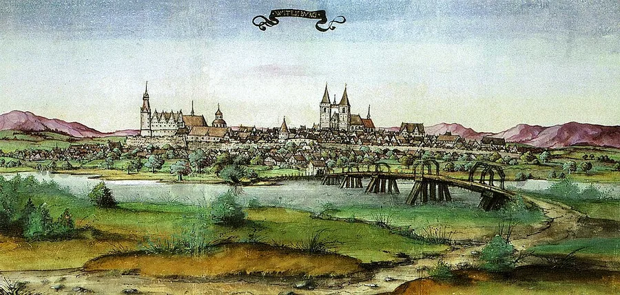 A 1536 hand-colored drawing labeled "Wittenberg," showing the town's church towers and rooftops along the Elbe river, with a long wooden bridge crossing the water in the foreground.